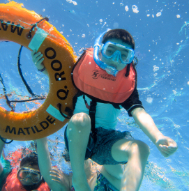 Child snorkeling holding float