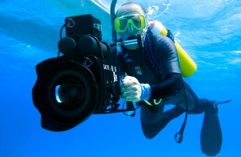 Diver near the surface holding an underwater video camera