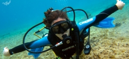 Newly certified scuba diver demonstrating her buoyacy skills underwater