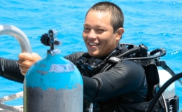 Divemaster climbing on boat ladder after a dive